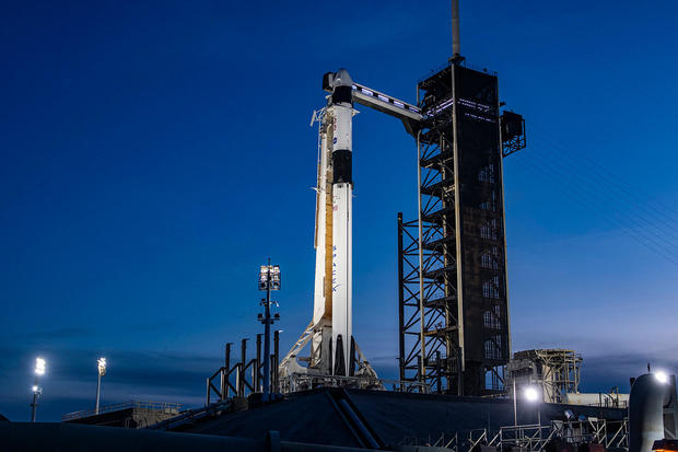 One woman and three men are prepared for their launch to the space station after delays due to weather.