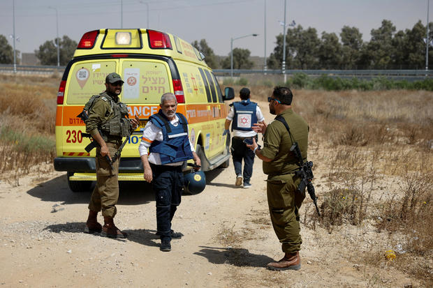 Israeli soldiers and medics walk near an ambulance after Palestinian Islamist group Hamas claimed responsibility for an attack on Kerem Shalom crossing 