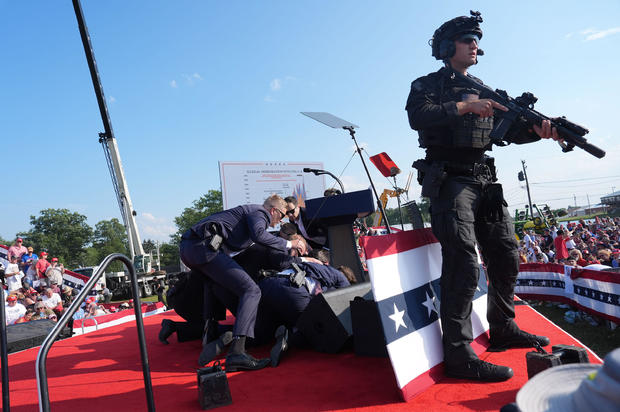 Secret service agents cover Trump on stage 