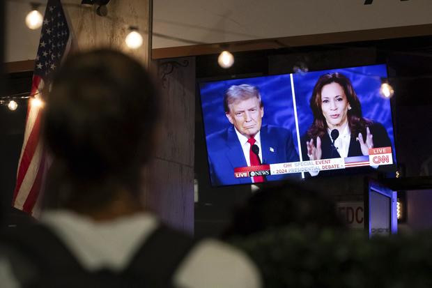 A TV screen displays the presidential debate between Kamala Harris and Donald Trump. 