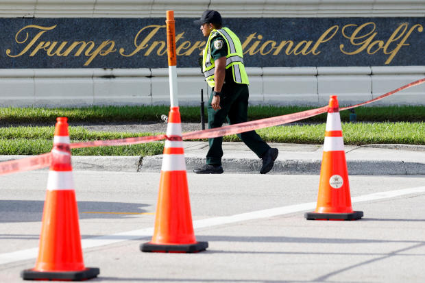 A law enforcement officer walks in front of a sign for former President Donald Trump's Trump International Golf Course in West Palm Beach, Florida, after shots were fired Sept. 15, 2024. 