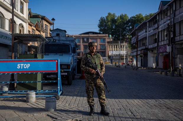 An Indian security force personnel stands guard on a street in Srinagar 